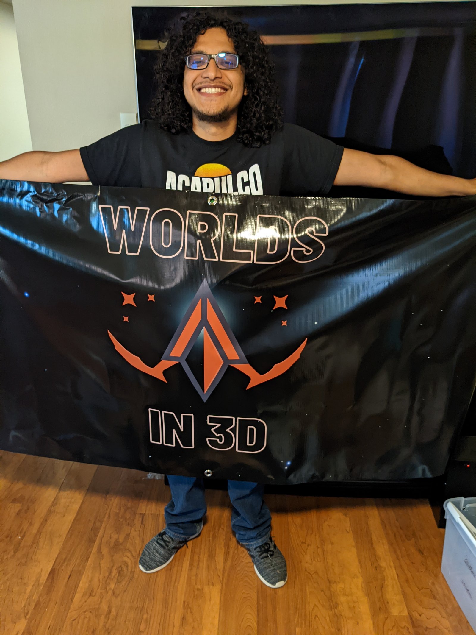 Owner of Worlds in 3D holding their banner